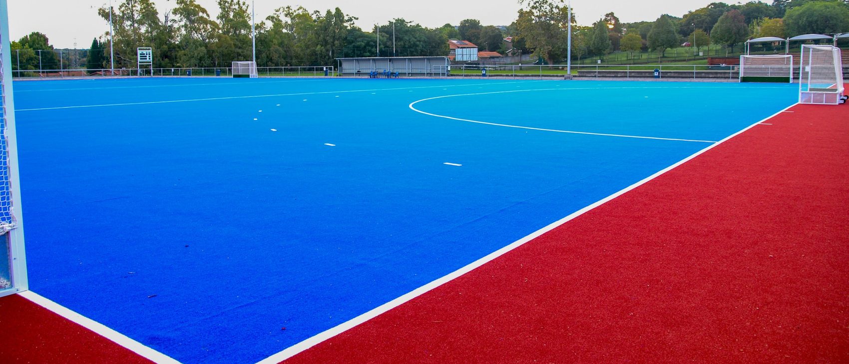 Blau-rotes Hockeyfeld mit Spielfeldmarkierungen