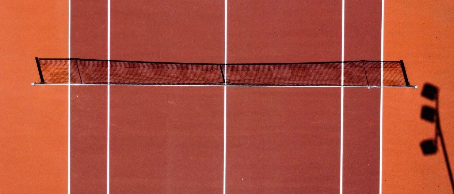 Tennisplatz aus der Vogelperspektive mit Netz und Linien